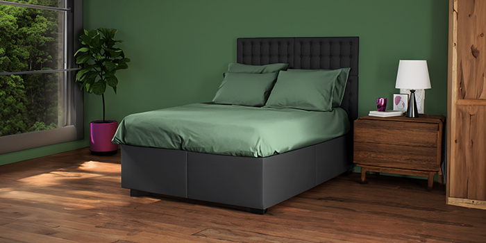 Lit sombre avec tête de lit et literie verte, table de chevet en bois dans une chambre à coucher stylée. Cliquez pour voir les produits de la collection. 